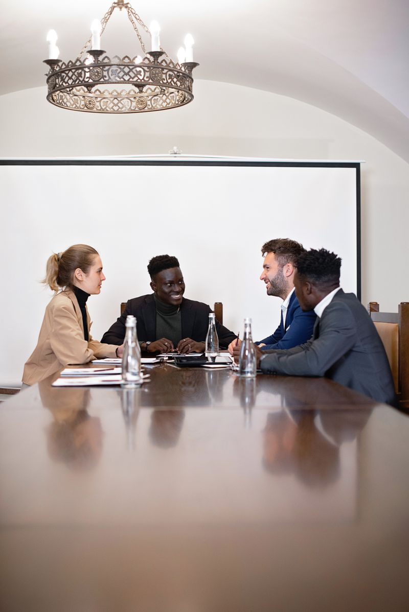 A diverse group of Black professionals discussing in a modern conference room setting, fostering teamwork.
